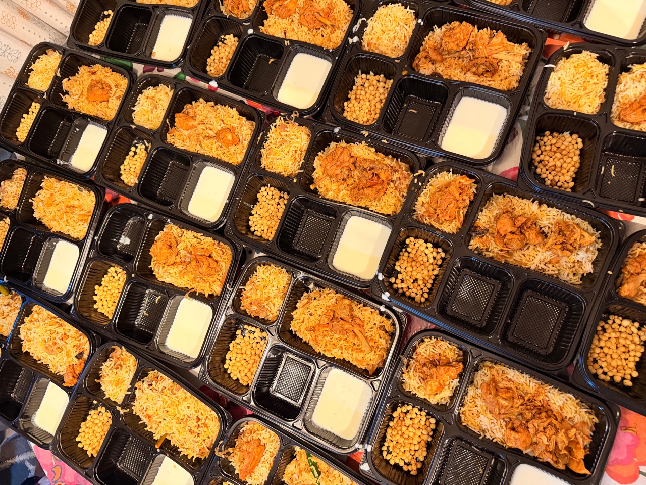 A large catering order of freshly packed biryani meals from Mom's Delight