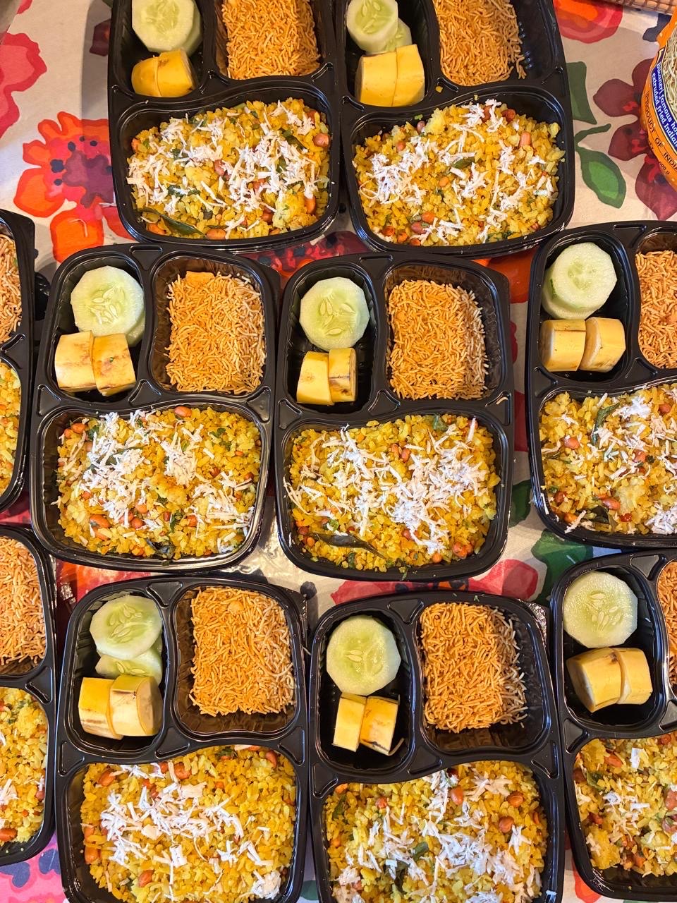 Poha meal boxes with fruit and sev prepared by Mom's Delight